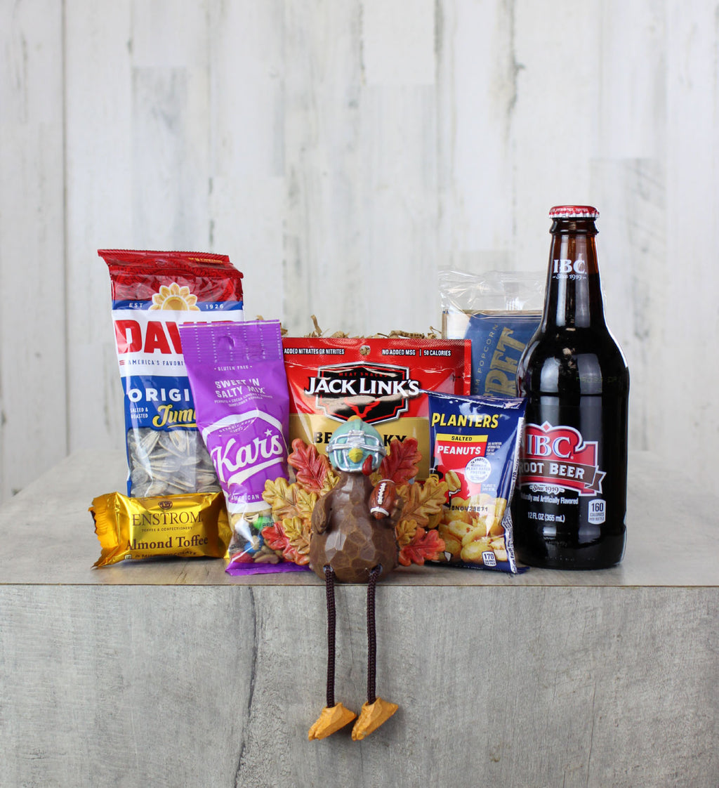 Gift basket in wooden box containing decorative football turkey and snacks.